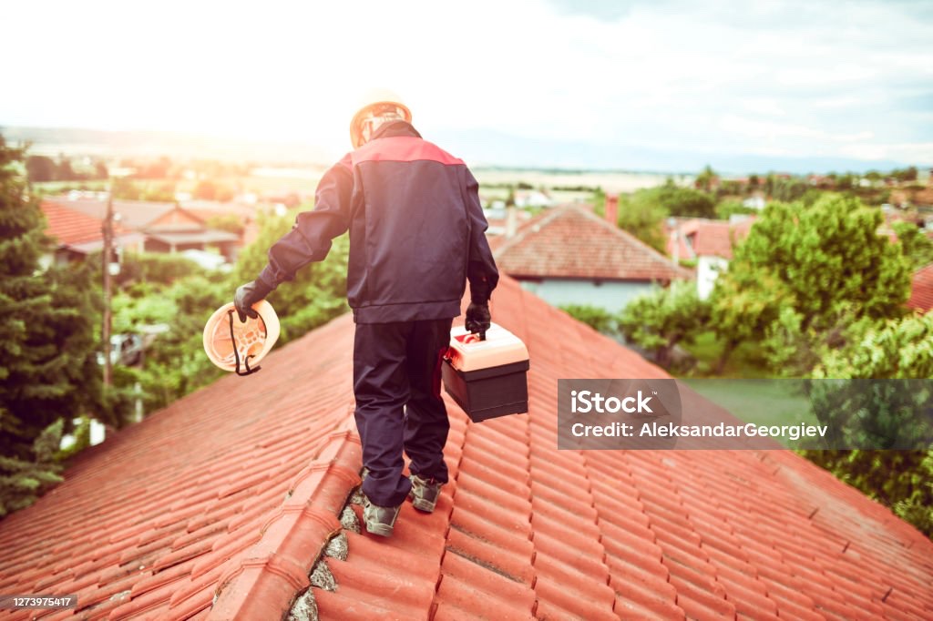 A typical inspector walking across a fragile tile roof